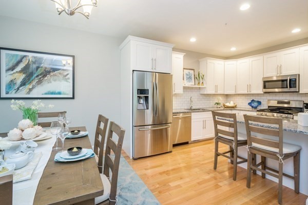 8 Campbell Road, Unit 42 Berlin, MA 01503 - Photo 7 of 13 a kitchen with stainless steel appliances a stove a refrigerator and a dining table with wooden floor