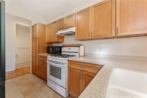 a kitchen with stainless steel appliances granite countertop a stove a sink and a refrigerator