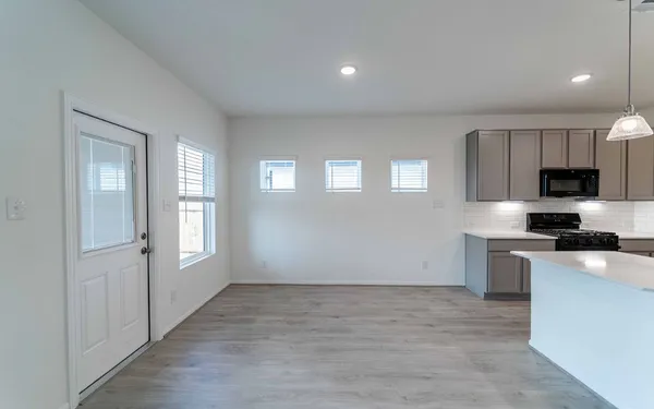 a kitchen with granite countertop a stove top oven and cabinets