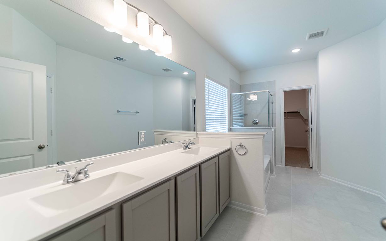 290 Yosemite Drive Kyle, TX 78640 - Photo 10 of 14 a bathroom with a double vanity sink and mirror