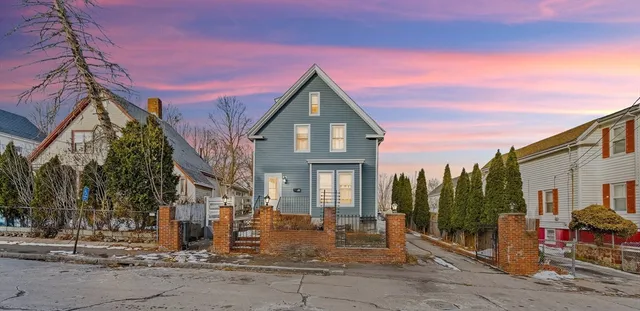 a view of a house with a wooden fence