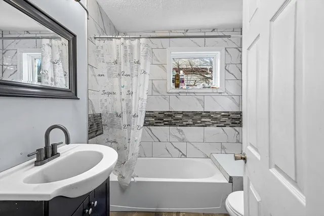 a bathroom with a sink a toilet and mirror