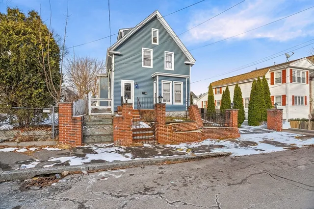 an aerial view of a residential apartment building with a yard and parking space