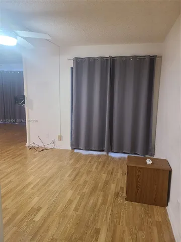 a view of a room with wooden floor