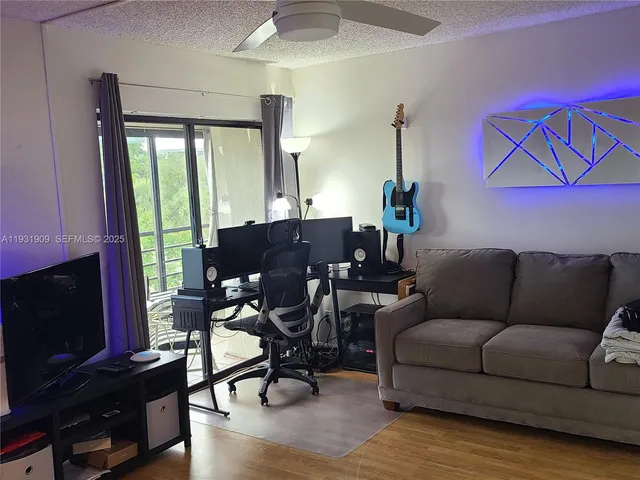 a living room with furniture a flat screen tv and wooden floor