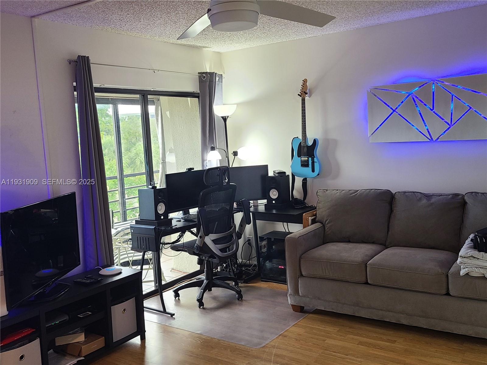 2306 South Cypress Bend Drive, Unit 418 Pompano Beach, FL 33069 - Photo 16 of 18 a living room with furniture a flat screen tv and wooden floor