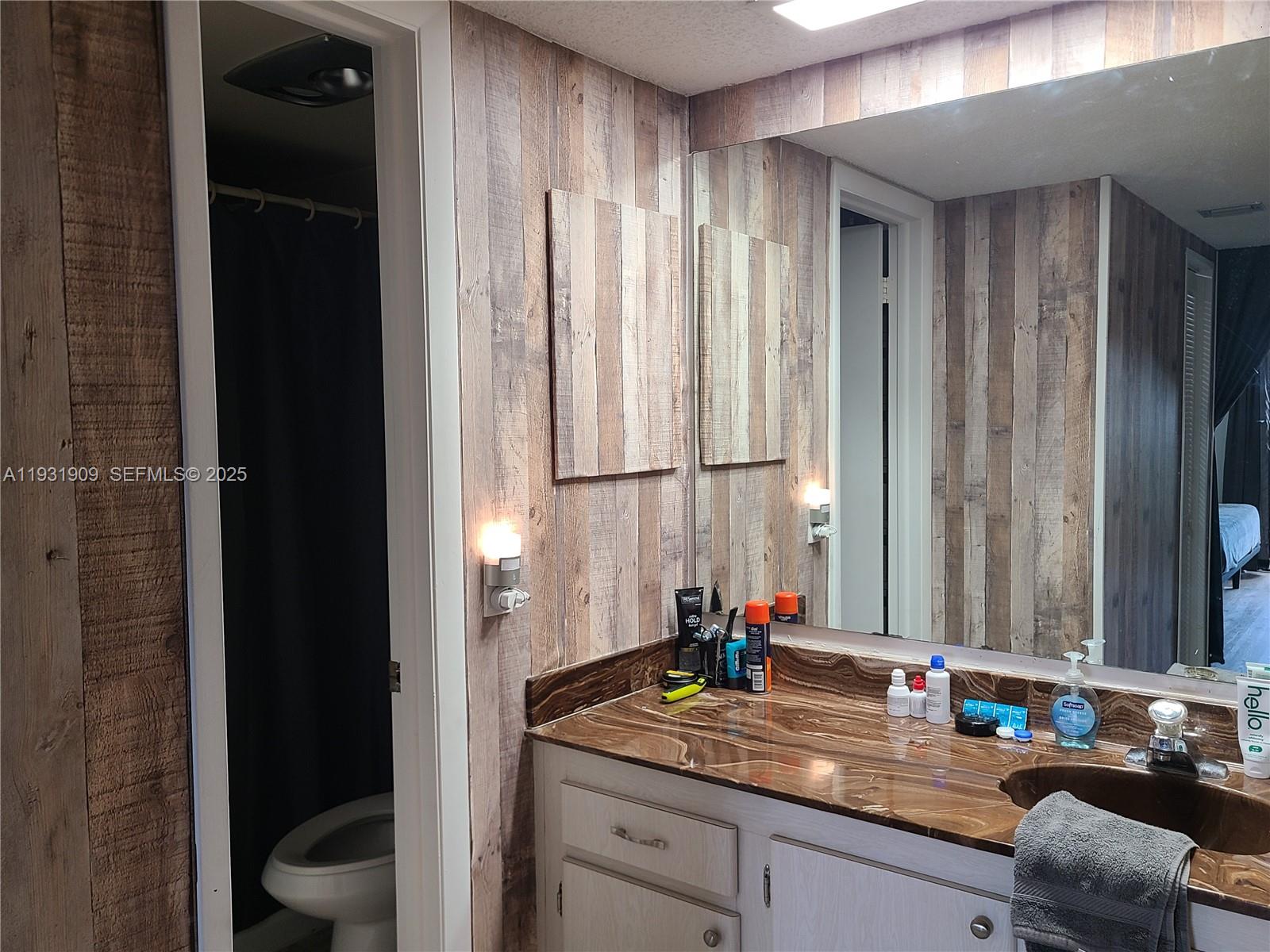 2306 South Cypress Bend Drive, Unit 418 Pompano Beach, FL 33069 - Photo 5 of 18 a bathroom with a granite countertop sink and a mirror