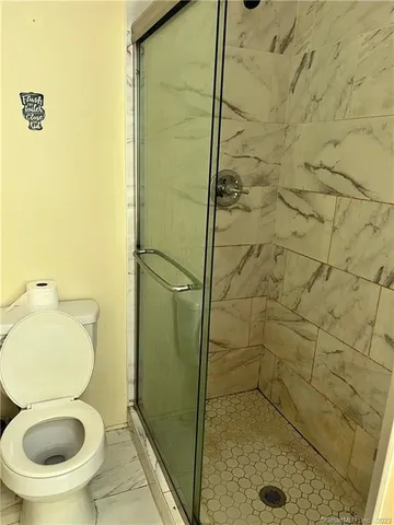 a bathroom with a toilet and a shower