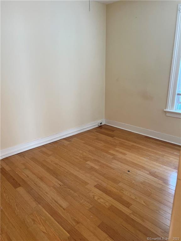 259 Humphrey Street, Unit 2 New Haven, CT 06511 - Photo 8 of 13 a view of an empty room with wooden floor and a window