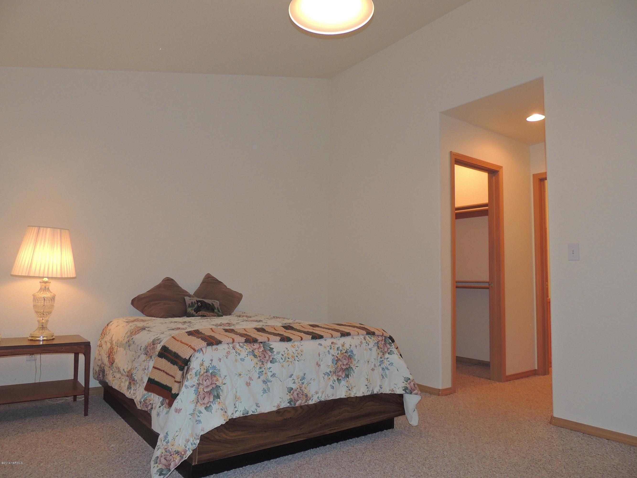 270 Red Tail Road Yakima, WA 98908 - Photo 44 of 69 a bedroom with a bed and a lamp