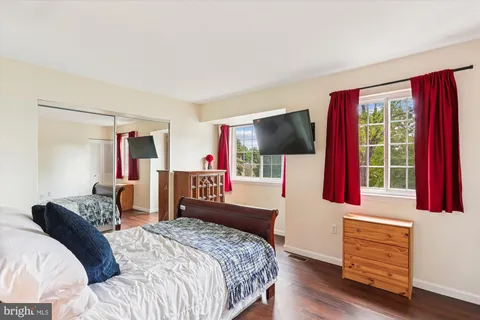 a bedroom with a bed dresser and a flat screen tv