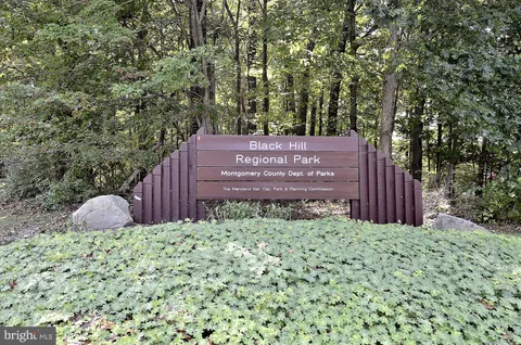 a front view of a house with a garden and lake view
