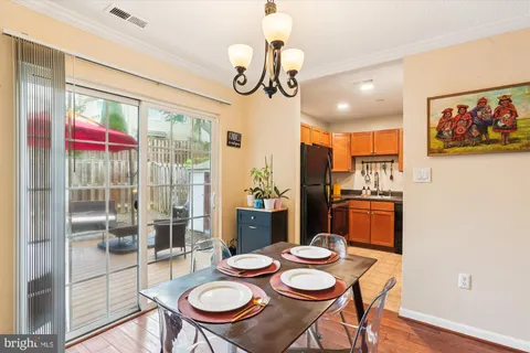 a view of a dining room with furniture a chandelier and wooden floor