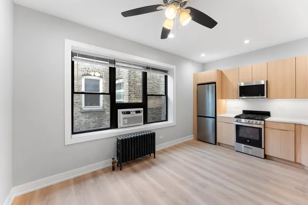 a living room with stainless steel appliances kitchen island granite countertop a stove and a refrigerator