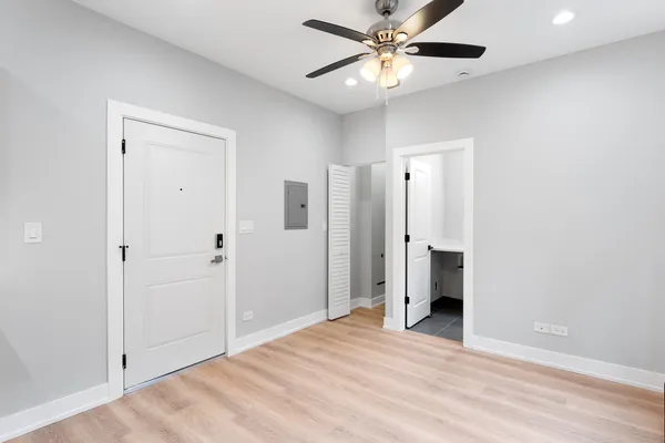 an empty room with closet and a ceiling fan