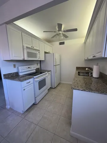 a kitchen with a stove top oven cabinets and a refrigerator