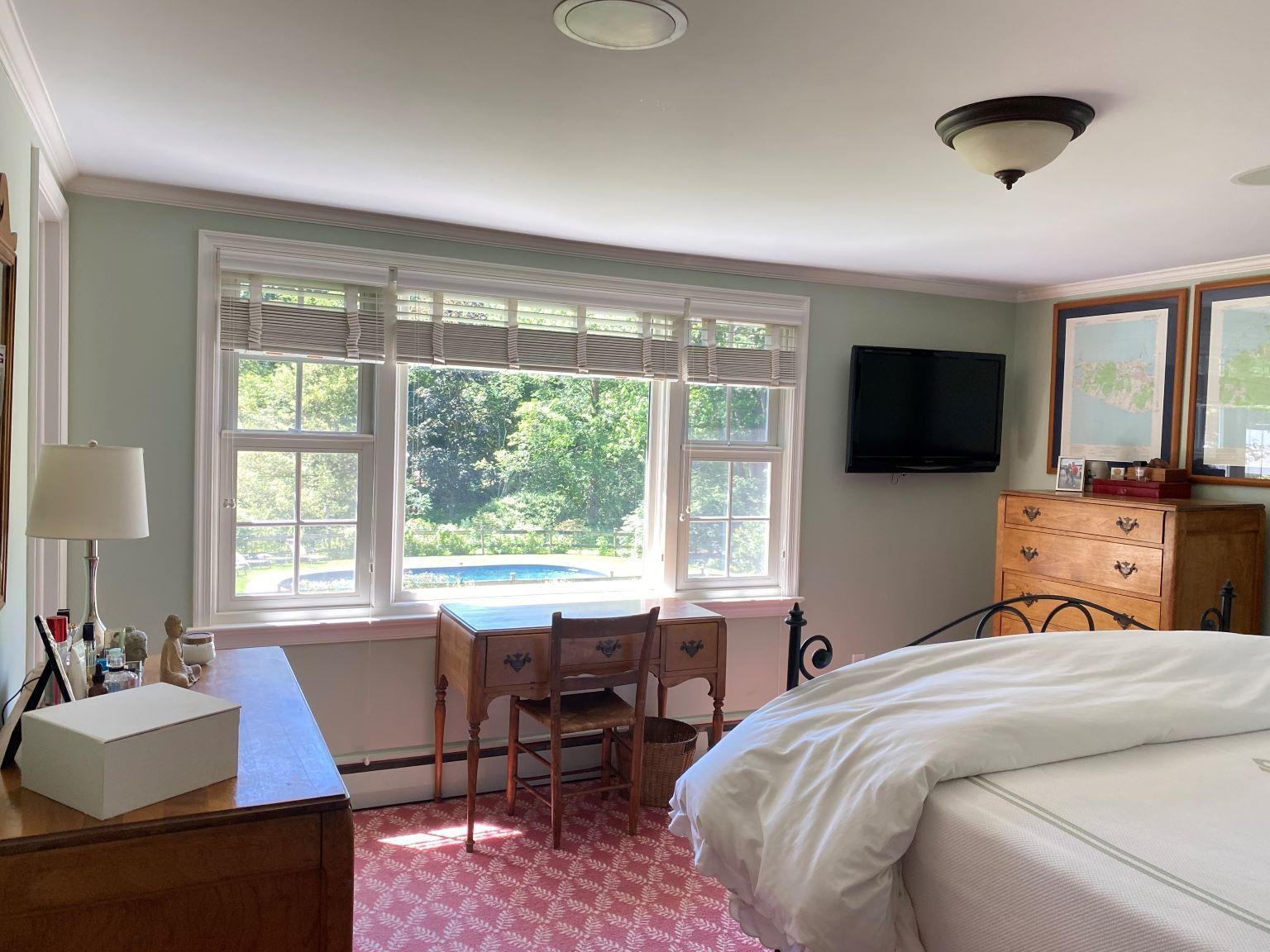 65 Conrad Road New Canaan, CT 06840 - Photo 9 of 12 a bedroom with a bed a large window and a flat screen tv