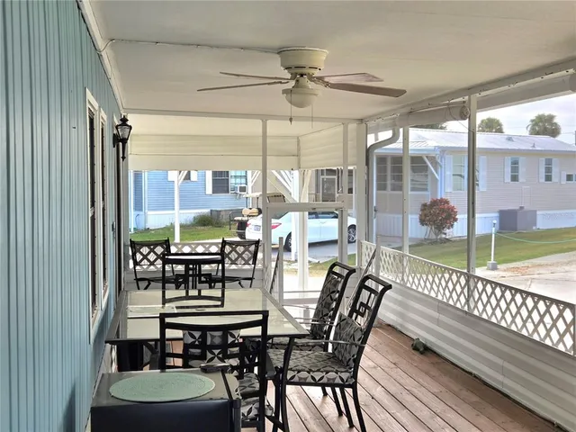 a living room with furniture a large window and wooden floor