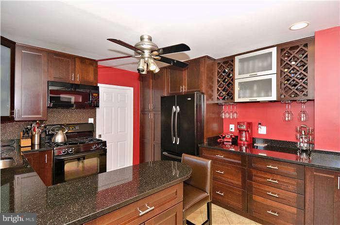 2204 Countryside Drive Silver Spring, MD 20905 - Photo 8 of 29 a kitchen with stainless steel appliances granite countertop a stove refrigerator and cabinets