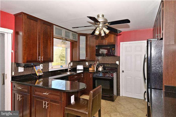 2204 Countryside Drive Silver Spring, MD 20905 - Photo 10 of 29 a kitchen with a refrigerator a sink and cabinets