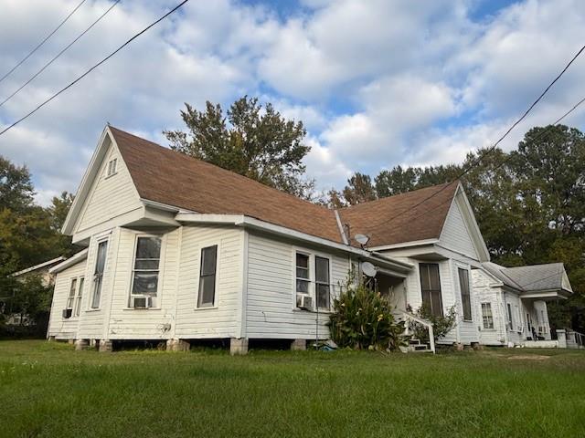 410 Marshall Street Minden, LA 71055 - Photo 3 of 4 a view of a white house next to a yard with potted plants and big trees