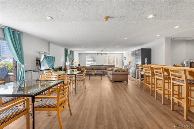 a living room with furniture a flat screen tv and a wooden floor