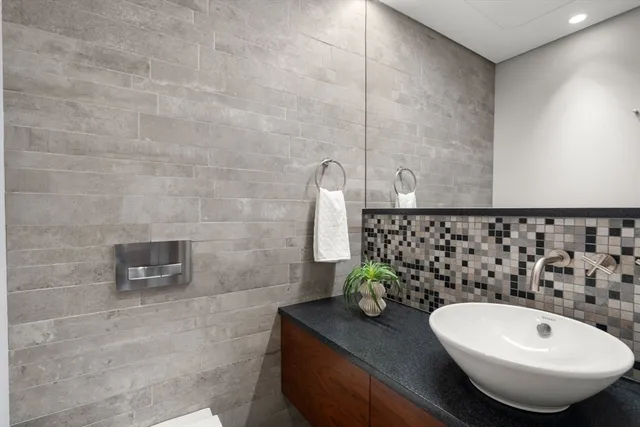 a bathroom with a granite countertop sink and a mirror