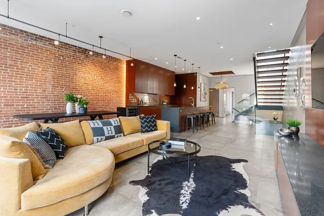 a living room with furniture kitchen view and a large window