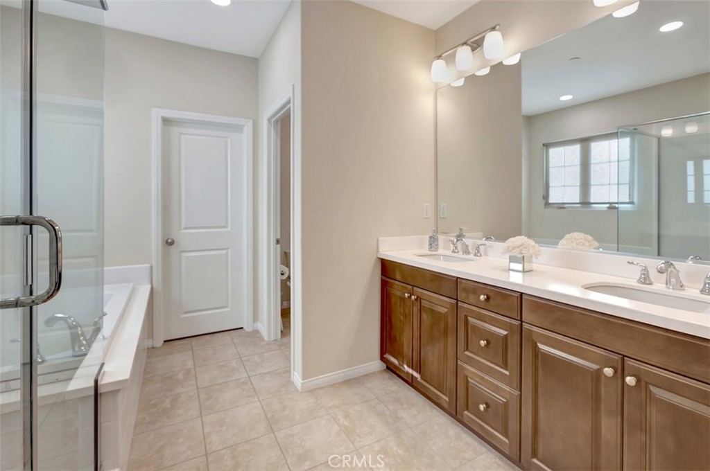 67 Hanging Garden Irvine, CA 92620 - Photo 15 of 23 a spacious bathroom with a double vanity sink a large mirror and a shower