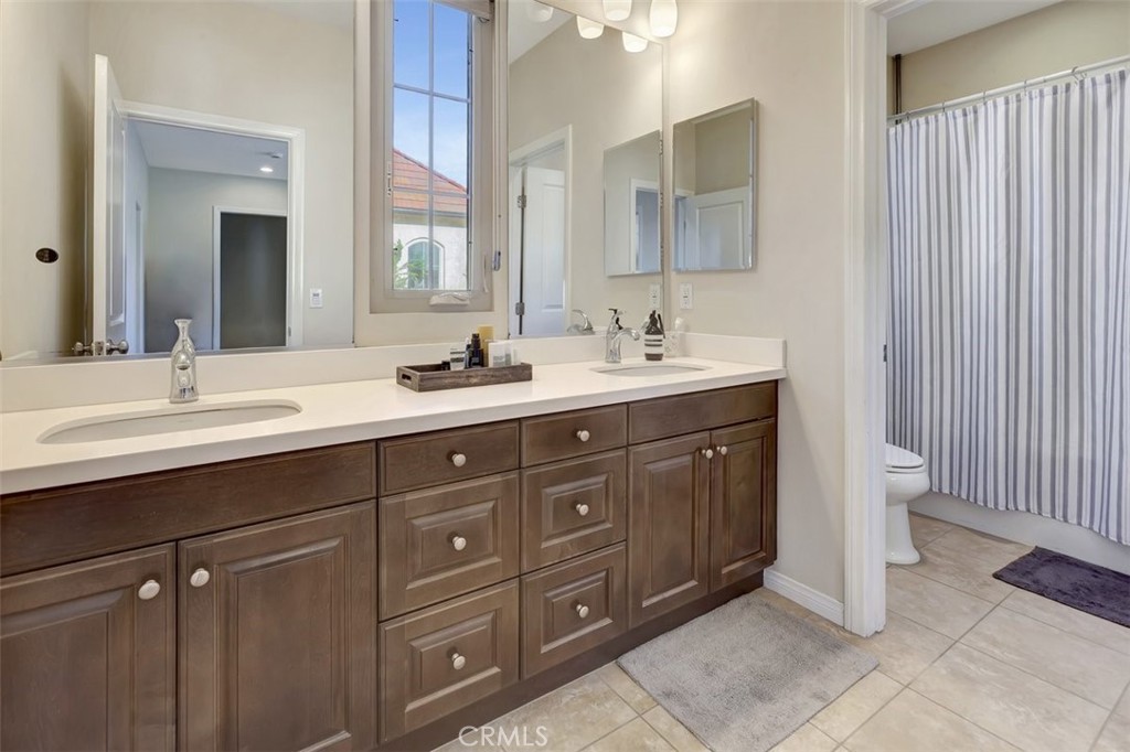 67 Hanging Garden Irvine, CA 92620 - Photo 17 of 23 a bathroom with a double vanity sink and a mirror