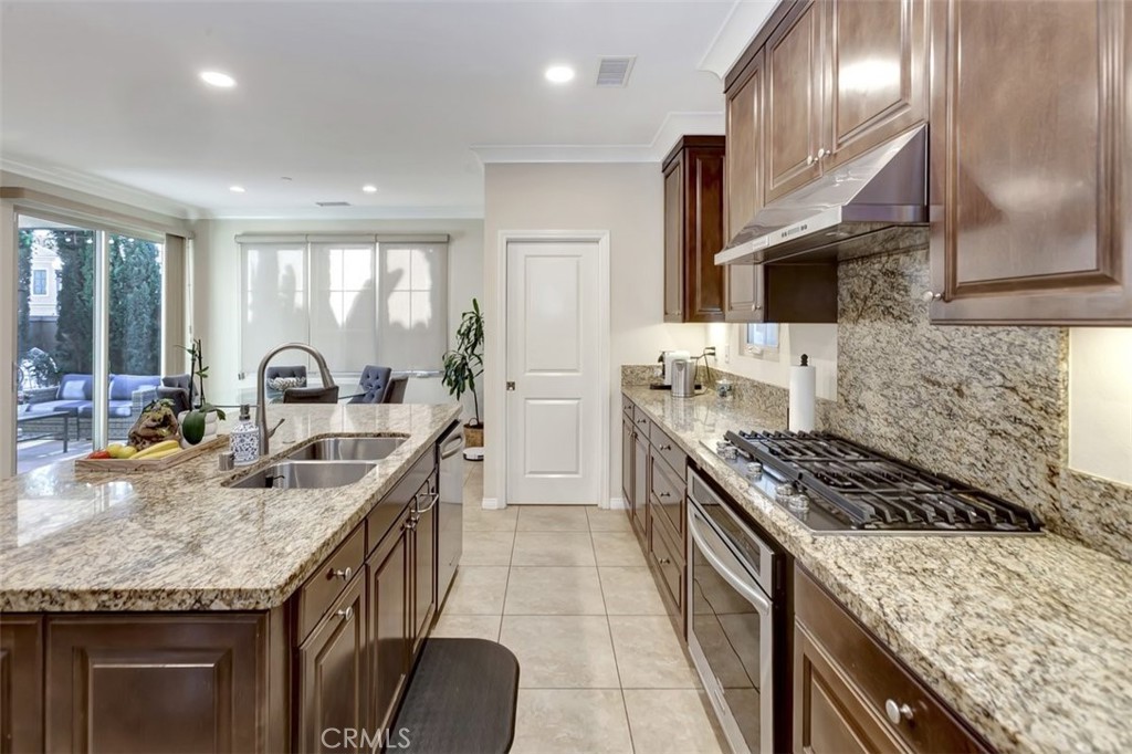 67 Hanging Garden Irvine, CA 92620 - Photo 6 of 23 a kitchen with granite countertop a sink stove and cabinets