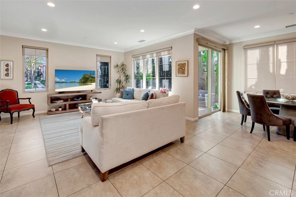 67 Hanging Garden Irvine, CA 92620 - Photo 10 of 23 a living room with furniture a large window and a flat screen tv
