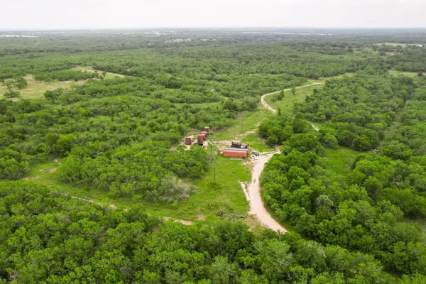 an aerial view of residential houses with outdoor space and trees