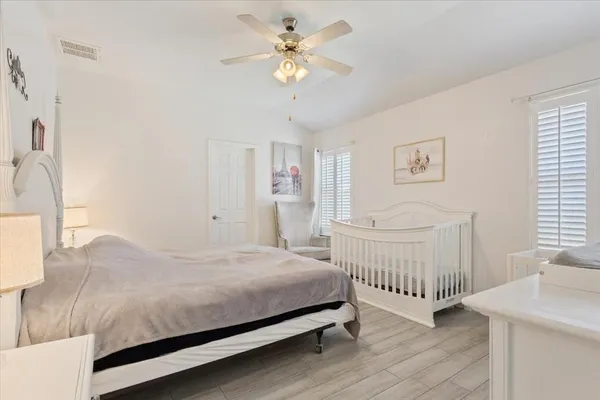 a bedroom with a bed a chandelier and a dresser