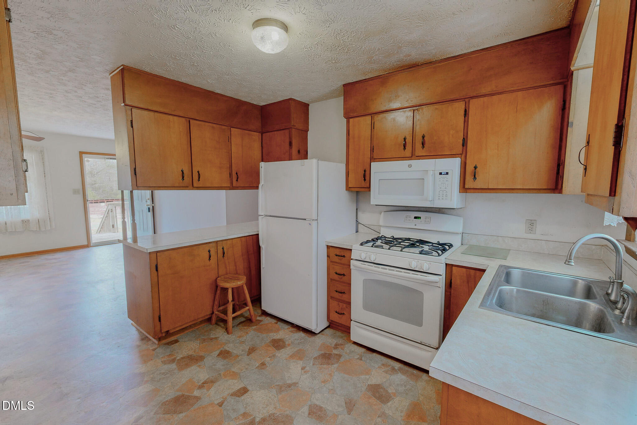 460 Medford Oakley Road Rougemont, NC 27572 - Photo 14 of 36 a kitchen with stainless steel appliances granite countertop a refrigerator a stove and a sink with wooden floors