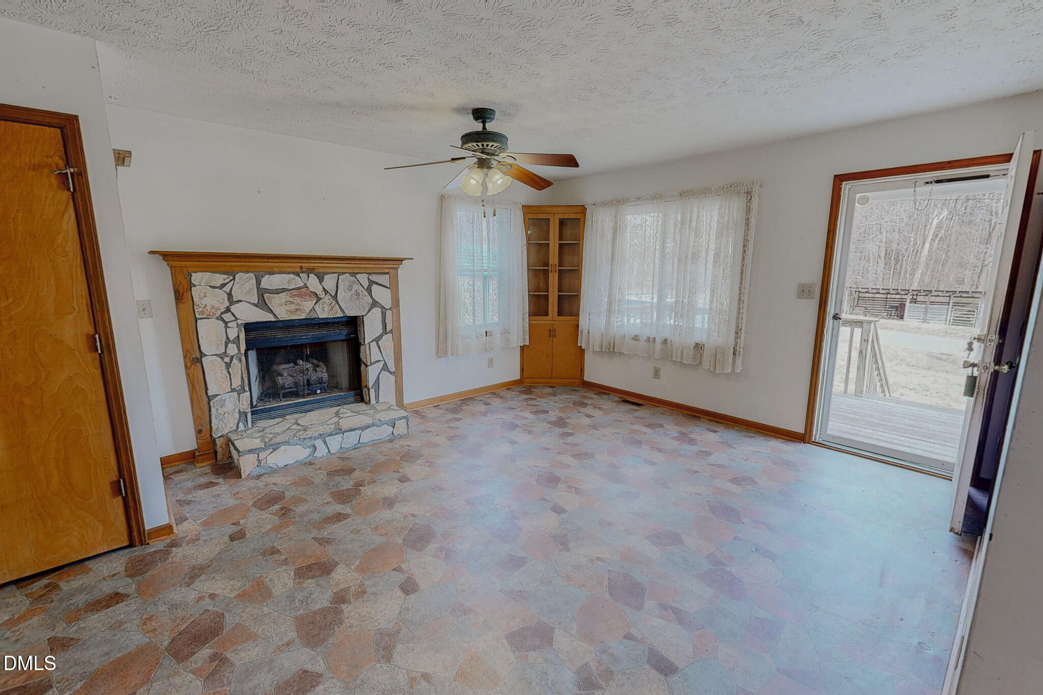 460 Medford Oakley Road Rougemont, NC 27572 - Photo 3 of 36 an empty room with windows fireplace and a kitchen view