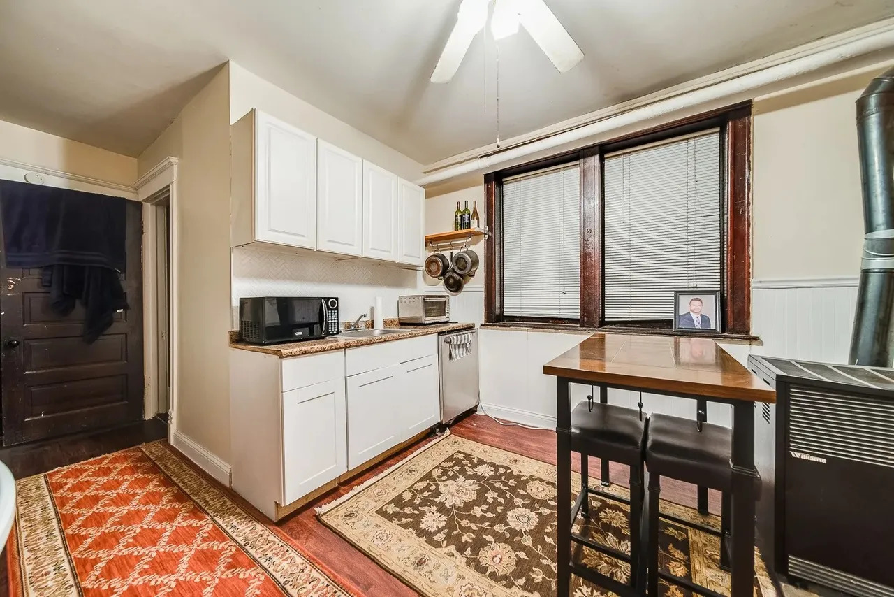 1308 West Byron Street, Unit G Chicago, IL 60613 - Photo 10 of 15 a kitchen with stainless steel appliances granite countertop a stove a sink and a refrigerator