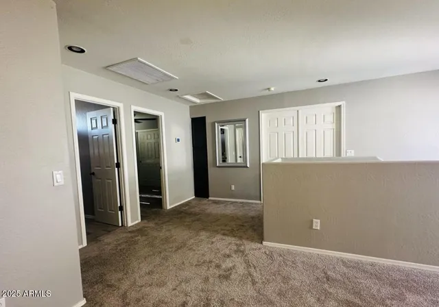 an empty room with closet and windows