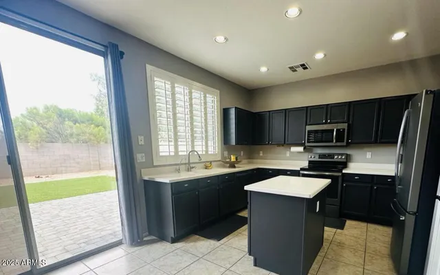 a kitchen with a sink a counter top space appliances and cabinets