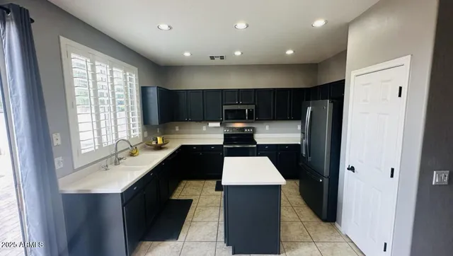 a kitchen with stainless steel appliances a sink cabinets and a refrigerator