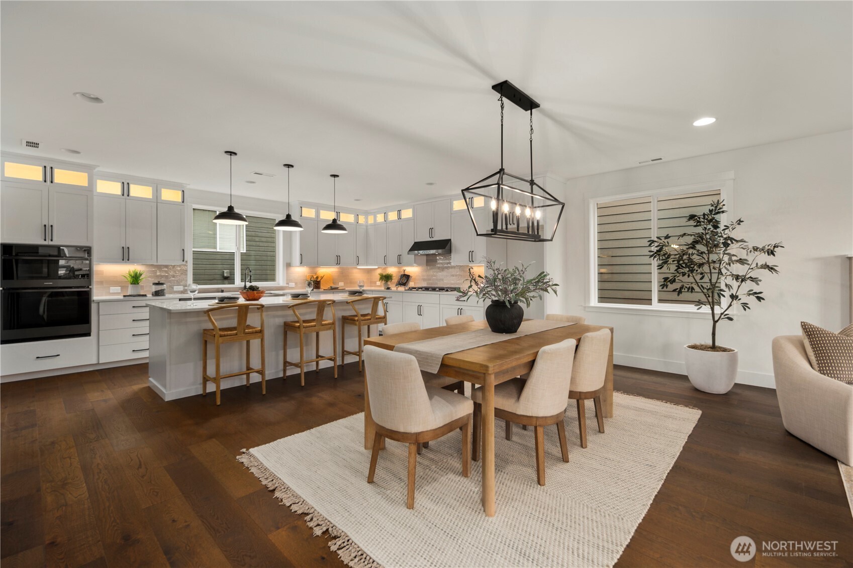 4128 220th Street Southeast Bothell, WA 98021 - Photo 5 of 31 a dining room with wooden floor a chandelier a wooden table and chairs