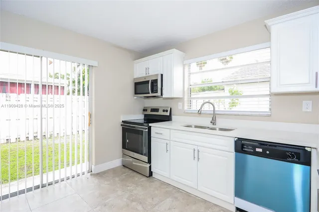 a kitchen with a sink stove top oven and cabinets