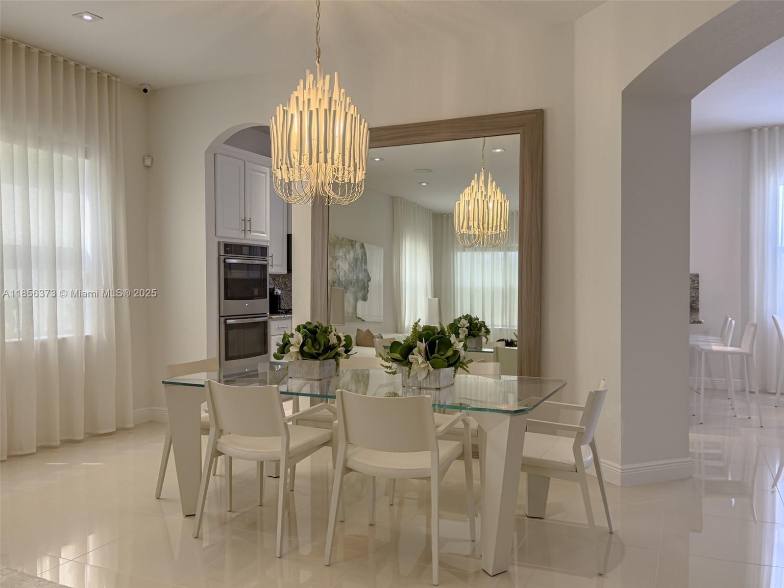 9709 Blue Isle Bay Parkland, FL 33076 - Photo 13 of 75 a view of a dining room with furniture and chandelier