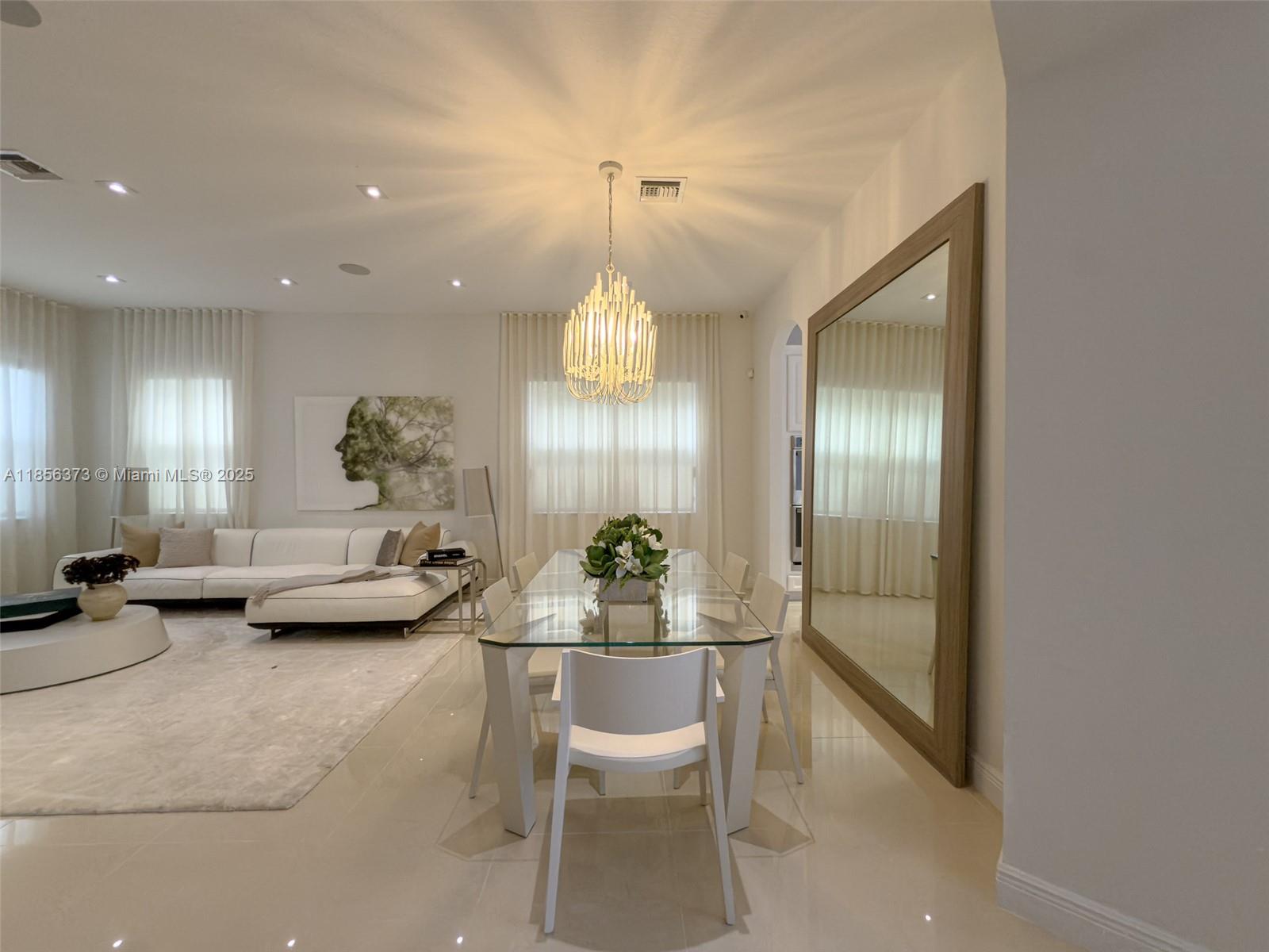 9709 Blue Isle Bay Parkland, FL 33076 - Photo 14 of 75 a dining room with furniture and a chandelier