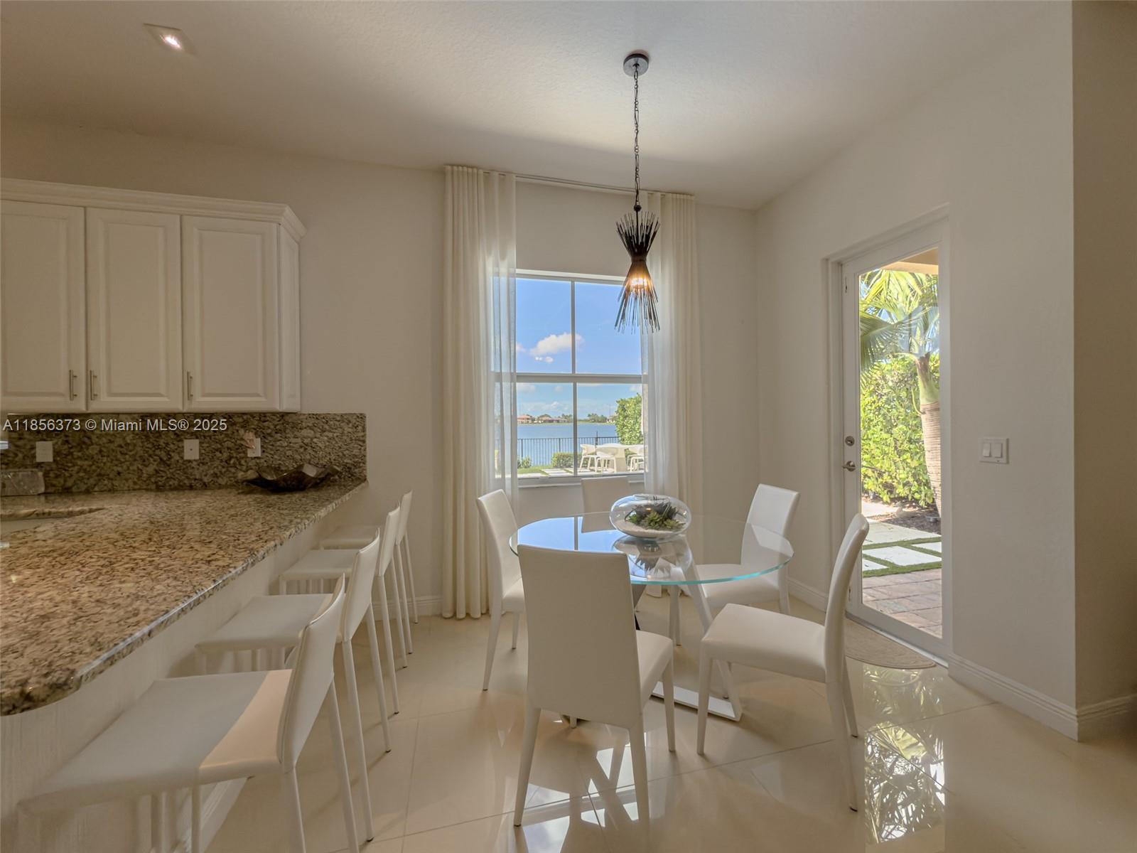 9709 Blue Isle Bay Parkland, FL 33076 - Photo 22 of 75 a view of a dining room with furniture window and outside view