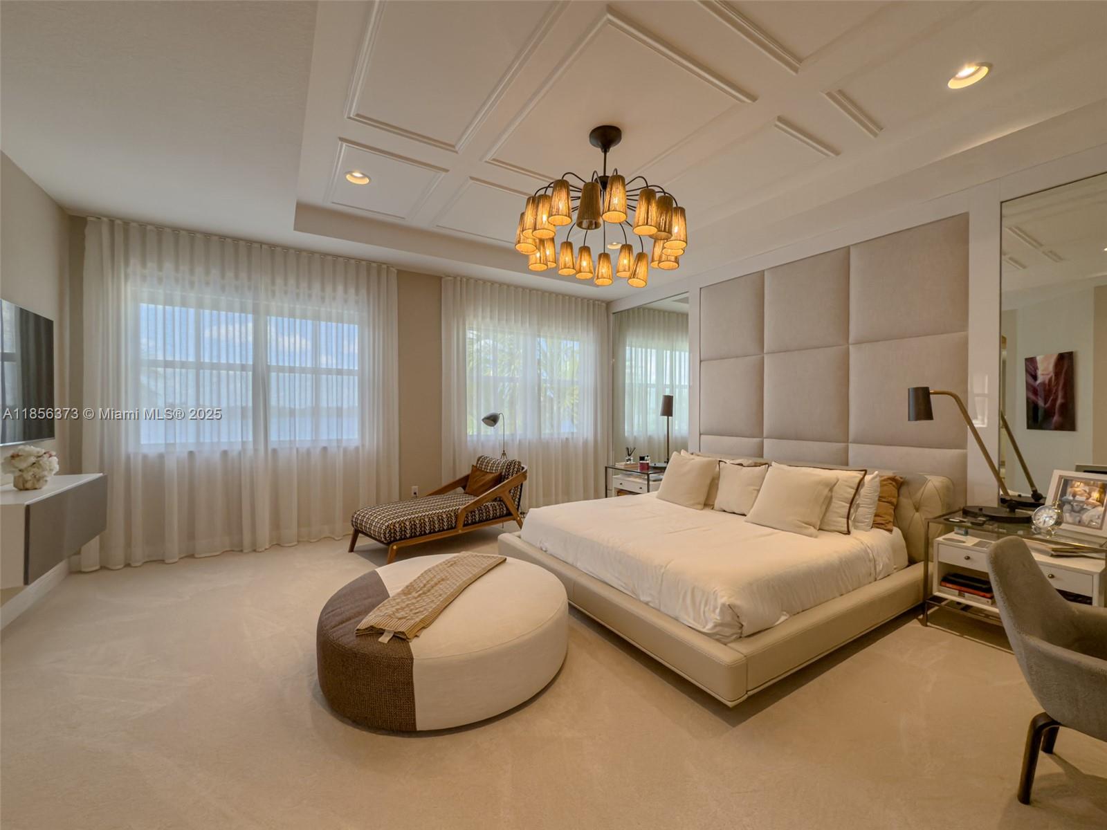 9709 Blue Isle Bay Parkland, FL 33076 - Photo 25 of 75 a spacious bedroom with a bed and a chandelier