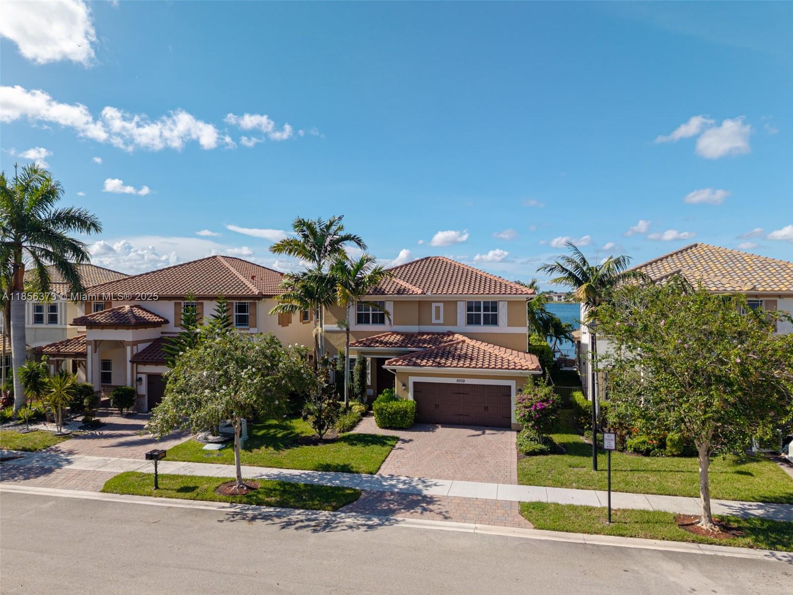 9709 Blue Isle Bay Parkland, FL 33076 - Photo 3 of 75 a front view of a house with a garden and plants
