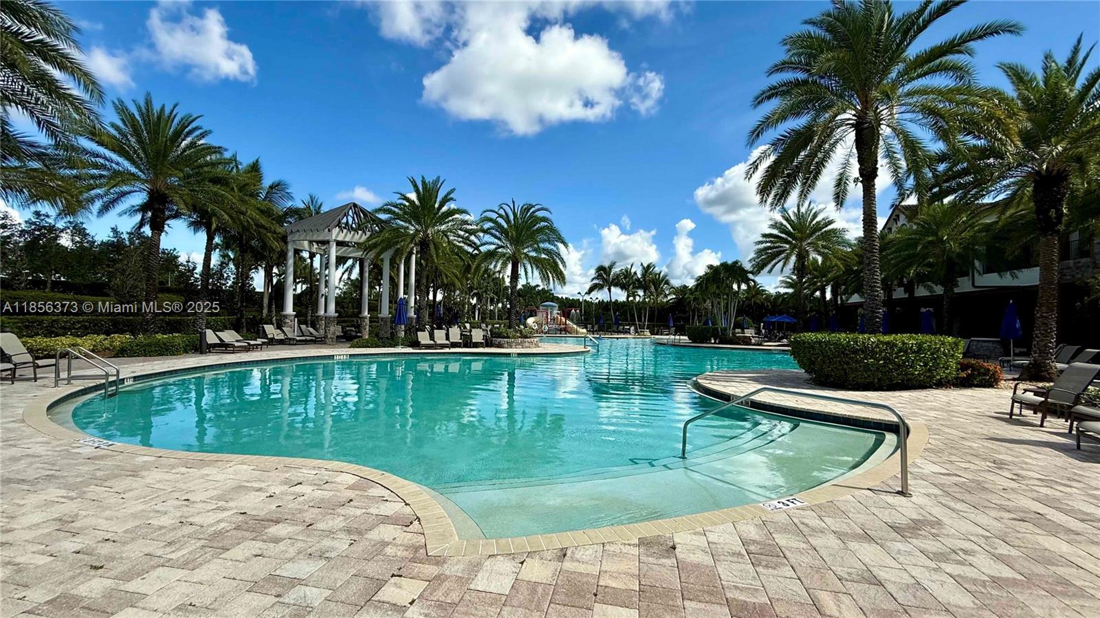 9709 Blue Isle Bay Parkland, FL 33076 - Photo 59 of 75 a view of a swimming pool with a garden and seating area