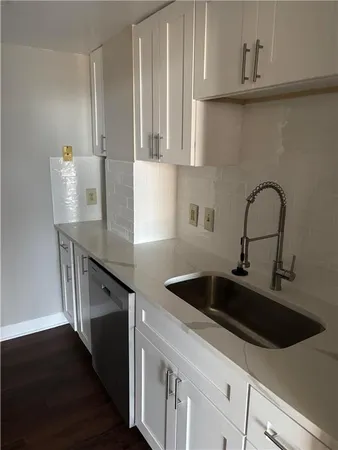 a kitchen with stainless steel appliances a sink a stove and cabinets