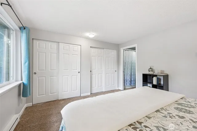 a bedroom with a large bed and wooden floor